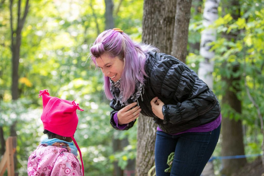 Éducatrice qui parle avec un enfant en forêt