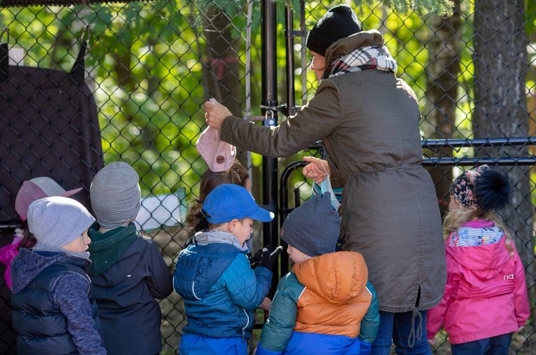 Éducatrice et enfants dans une cour extérieure