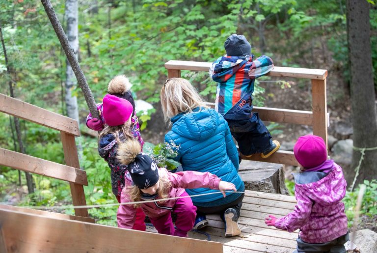 Enfants et éducatrice dans une structure de jeu en bois
