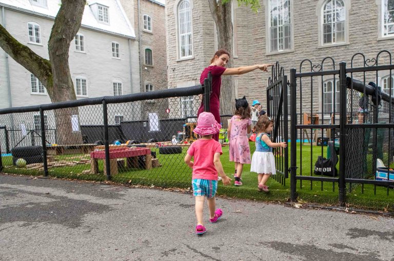 Enfants qui jouent dans une cour entourée d'une clôture